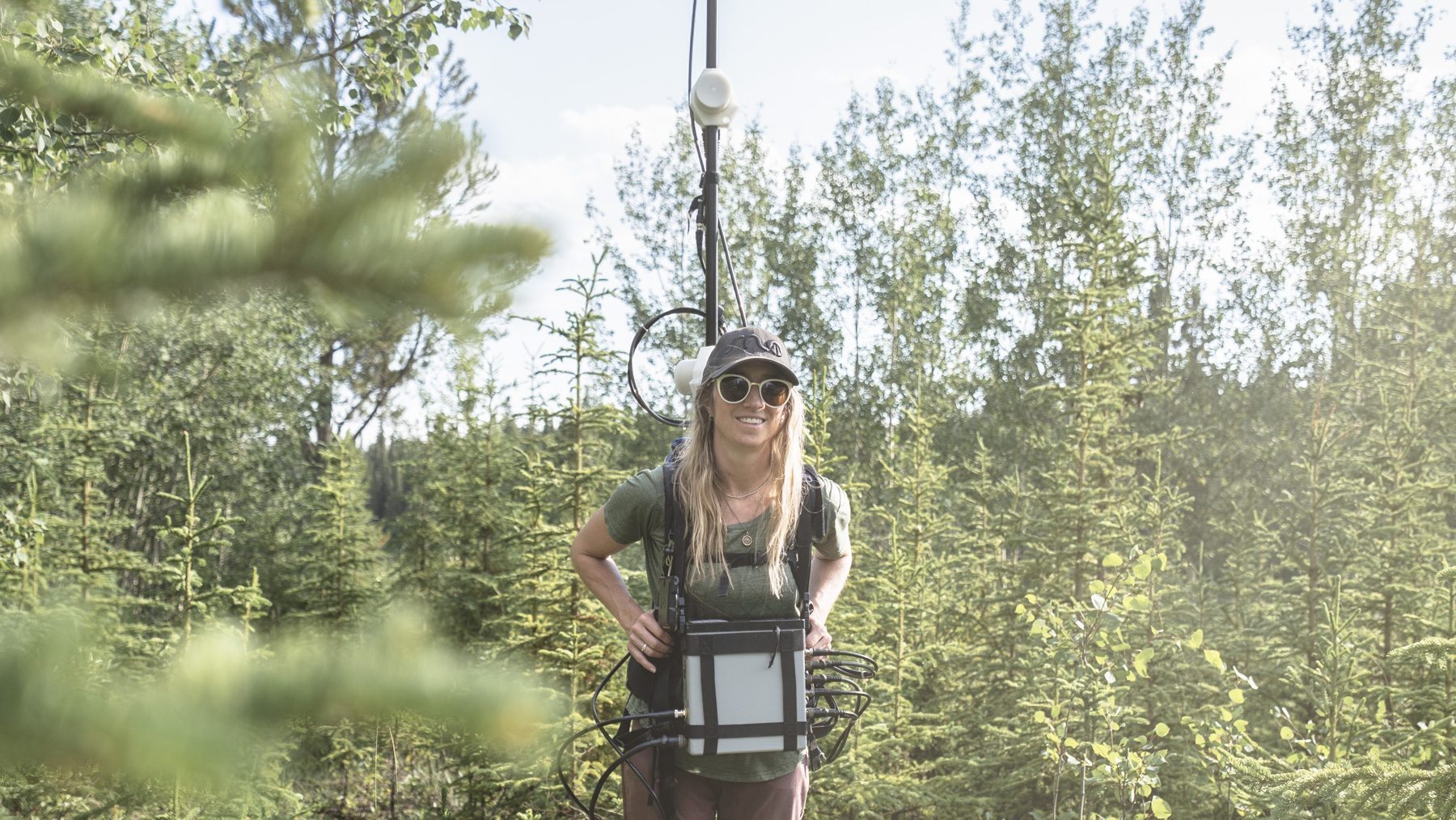 Geologist carrying a geophysics survey pack, used in sustainable mineral exploration