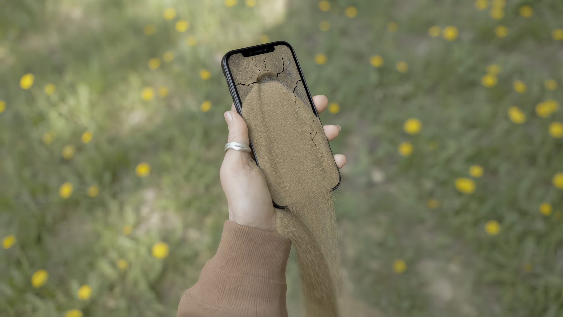 Smartphone dissolving into mineral sand, illustrating the minerals inside a phone